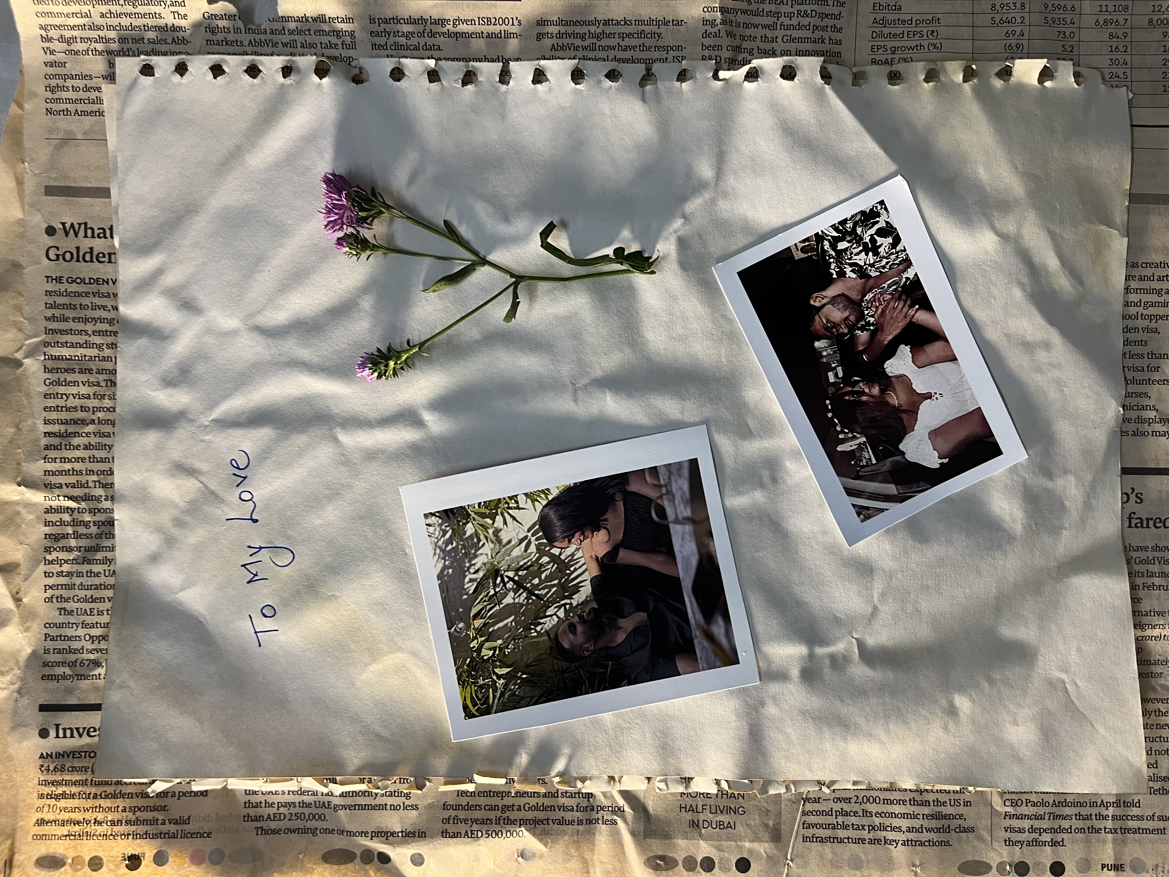 A small flower and two polaroids with a note 'To my love'
